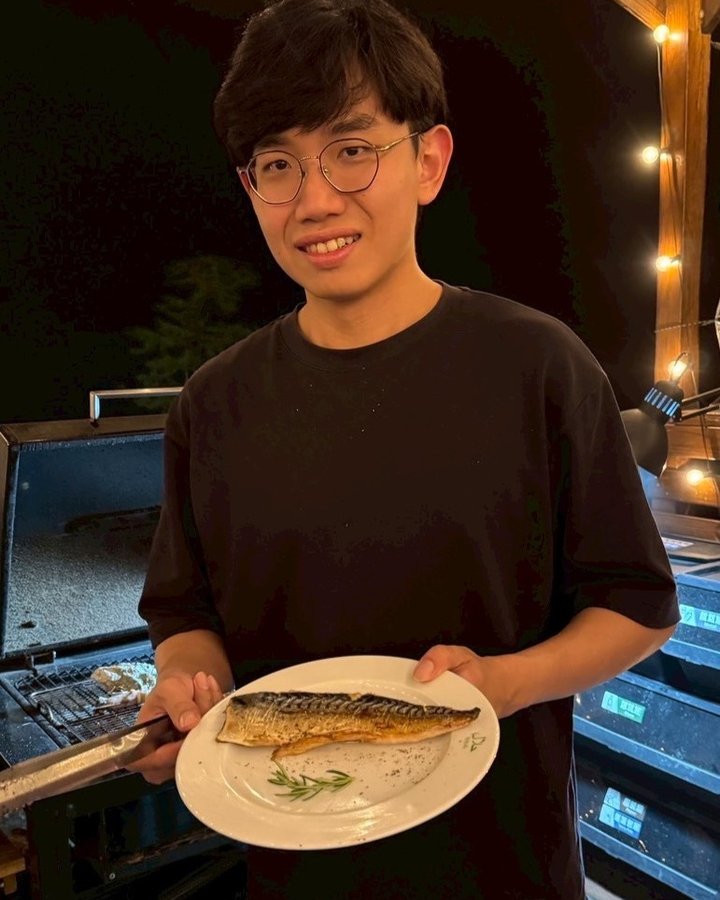 Kai holding a plate of grilled fish